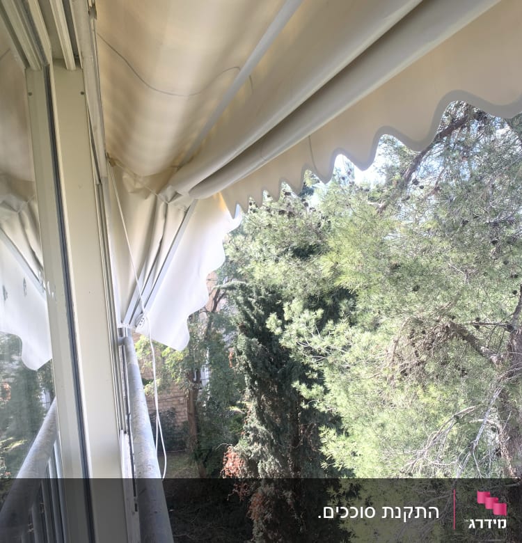 סוכך בד לבן עם קצוות גליים על מרפסת